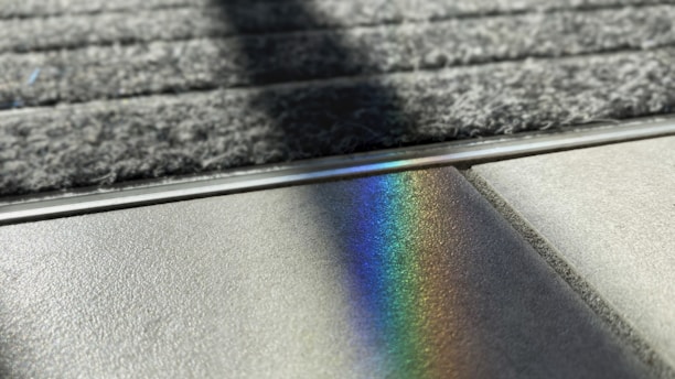 a rainbow of light shining on the surface of a rug
