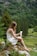 A smiling woman enjoying Urban Vida Naturals products in a serene setting.