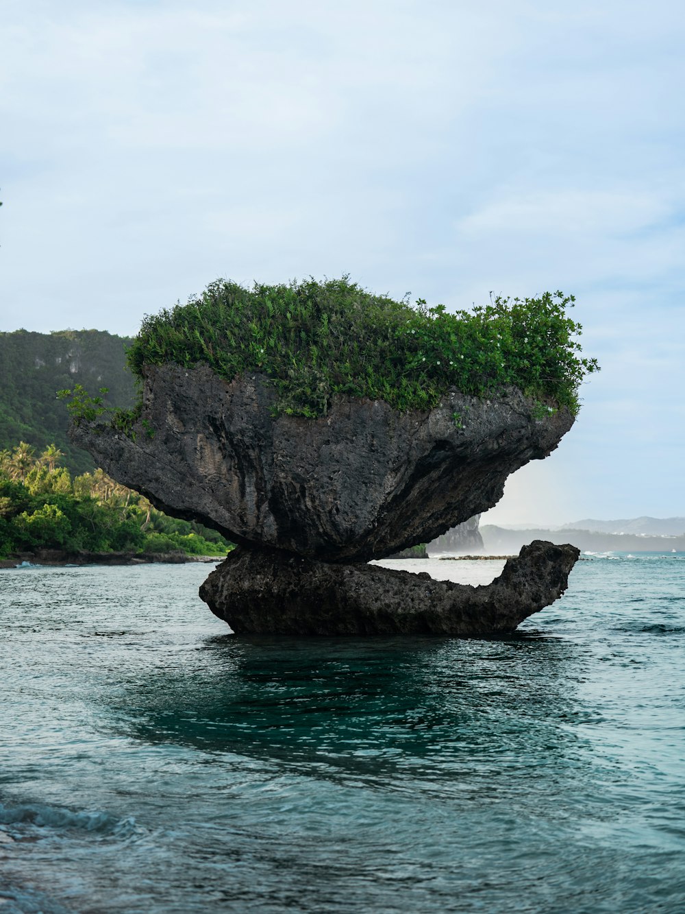 a rock formation in the middle of a body of water