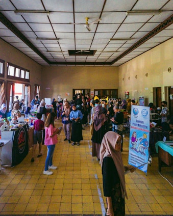 A vibrant event setup with booths, decorations, and happy attendees engaging in a lively exhibition hall.