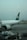 A large passenger airplane is parked at an airport terminal. The plane has the marking 'PIA' on its tail and 'INTERNATIONAL' along its fuselage. Ground support equipment, such as a mobile stairway and service vehicles, are positioned near the aircraft. The sky is overcast, giving a muted and calm atmosphere to the scene.