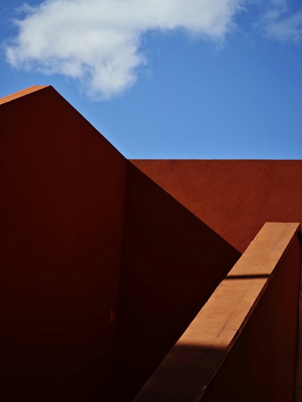 a red wall with a blue sky in the background