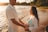 a man and a woman holding hands on the beach