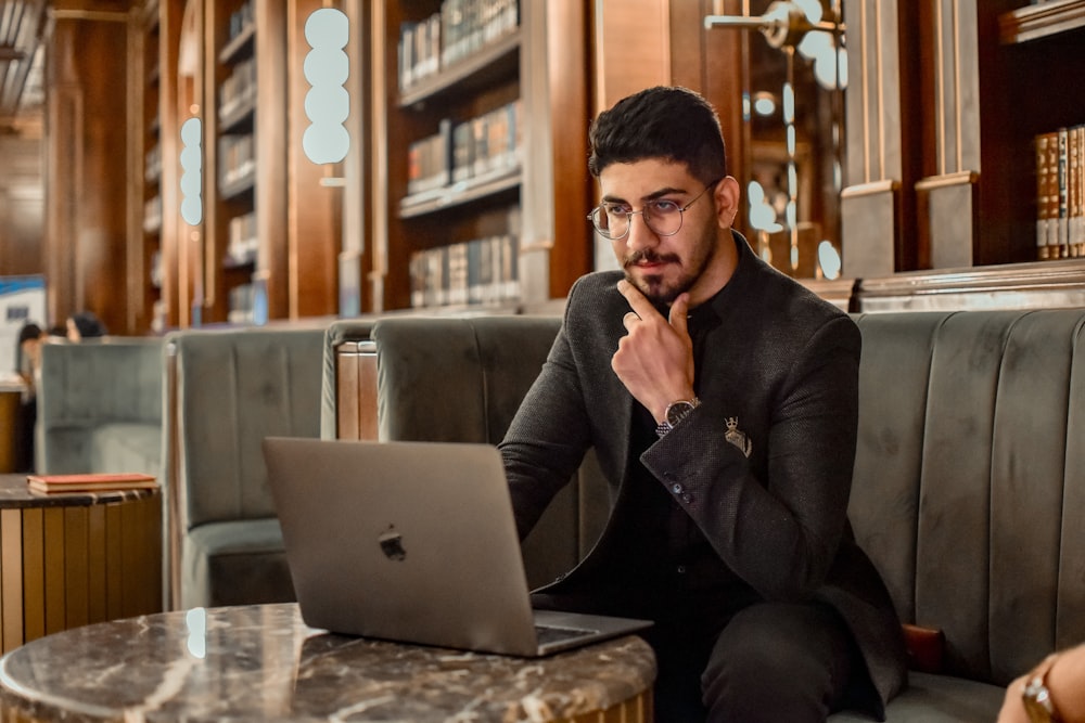 a man sitting on a couch using a laptop computer