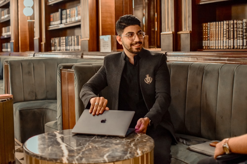 a man sitting at a table with a laptop