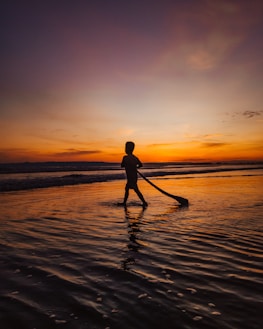 A vibrant Miami beach sunset with a casual fashion silhouette walking along the shore.