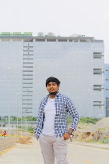 A stylish man wearing a casual shirt and jeans, standing confidently on Rohtak Road