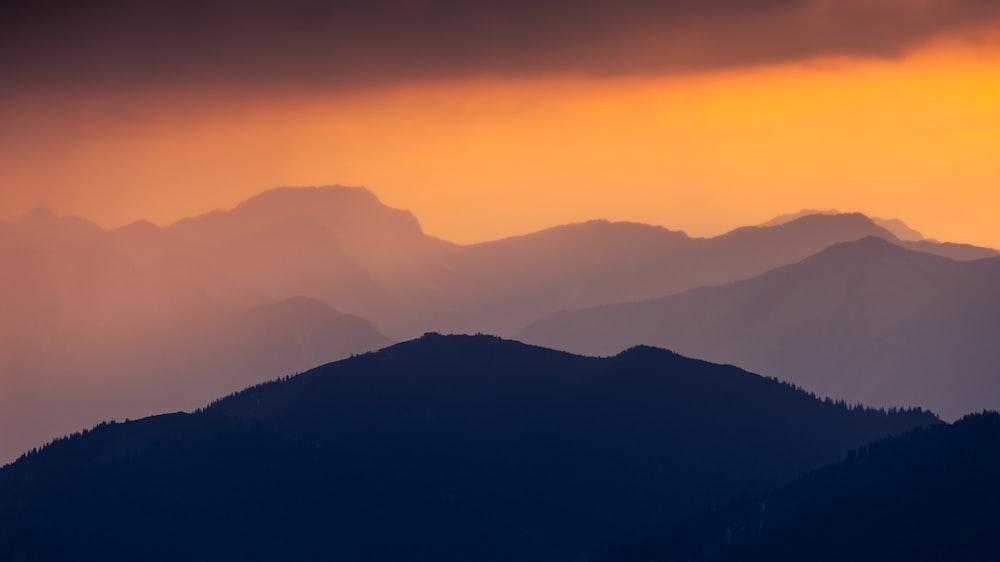 una vista di una catena montuosa al tramonto