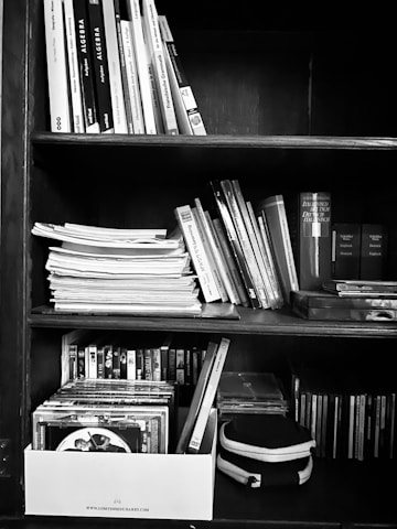 Stack of colorful DVDs and movie memorabilia on a wooden shelf