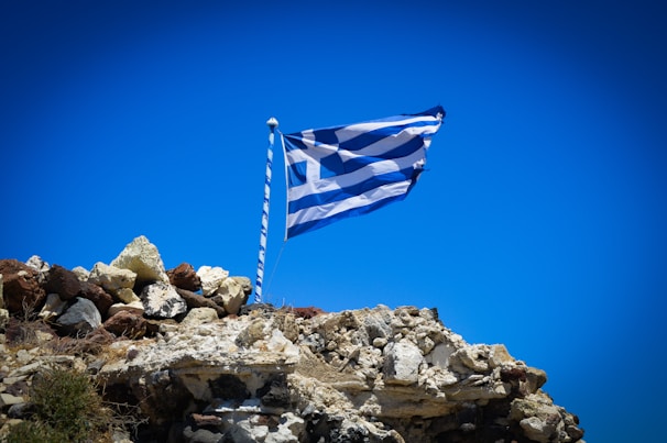 a flag flying on top of a rocky hill