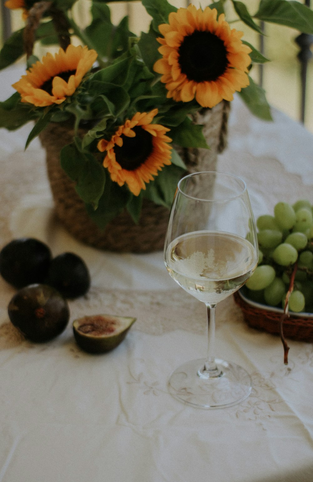 a glass of white wine sitting on a table