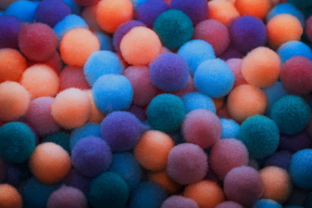a pile of multi colored pom poms