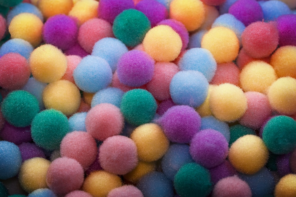 a pile of multi colored pom poms