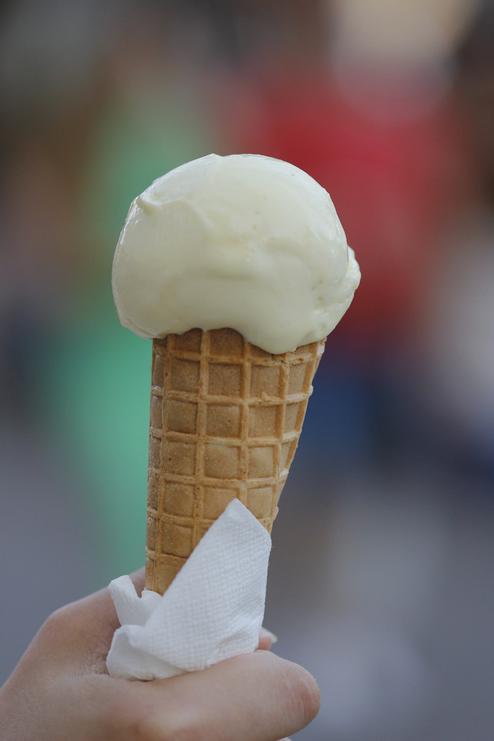 a hand holding a cone of ice cream