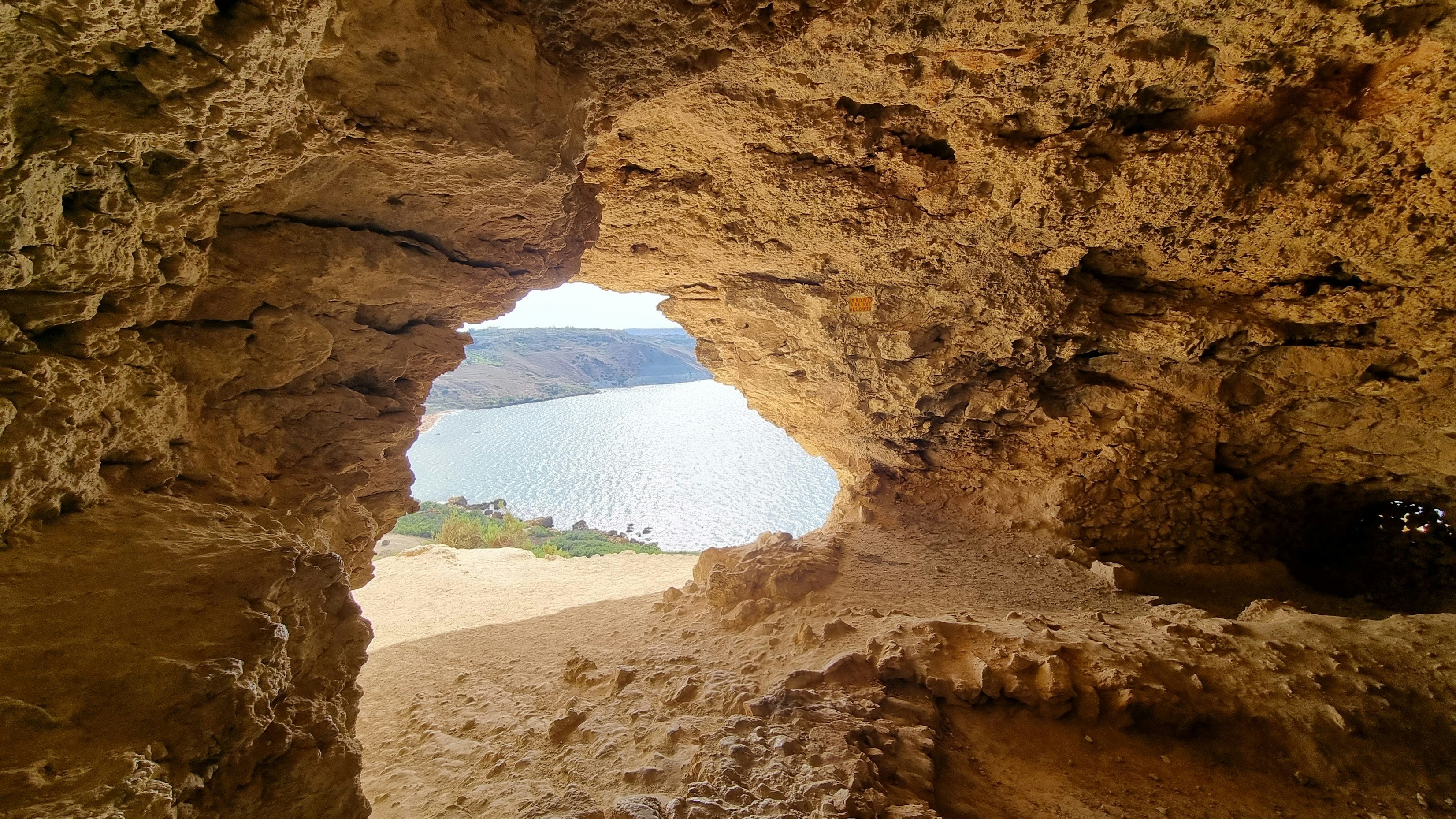 a view of a body of water through a cave