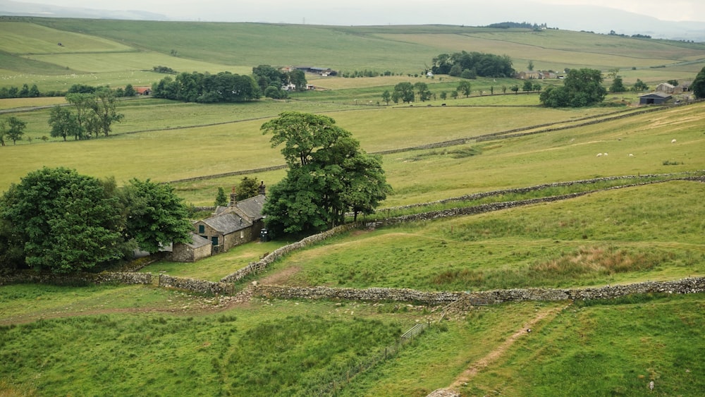 an aerial view of a farm with a stone wall in the foreground
