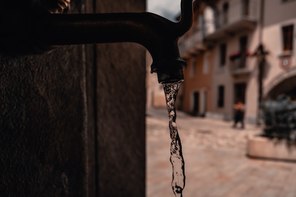 ein Wasserhahn, aus dem Wasser auf einer Straße läuft