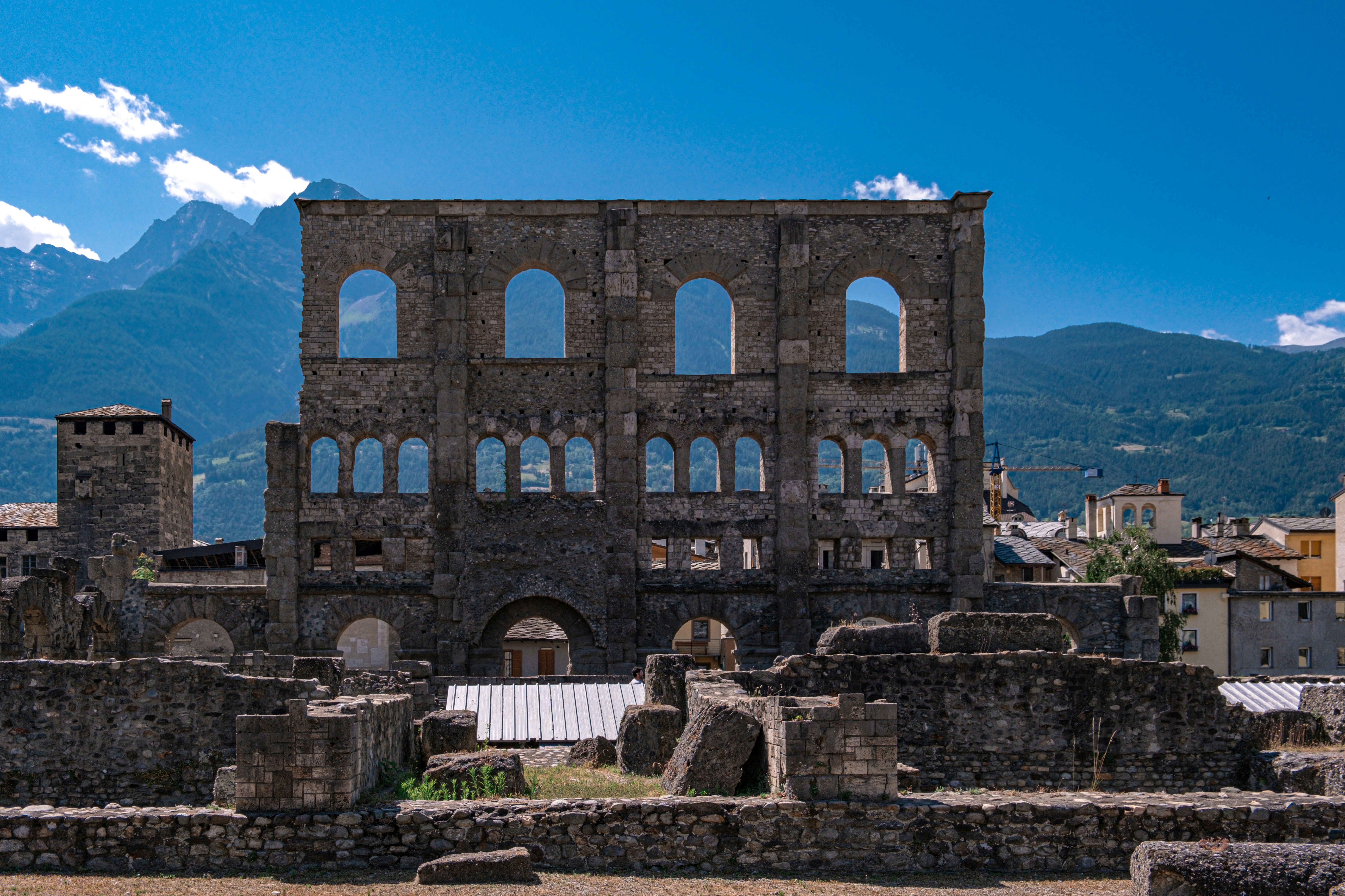 the ruins of a building with mountains in the background, 