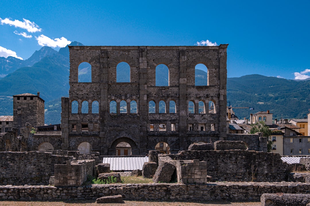 the ruins of a building with mountains in the background,