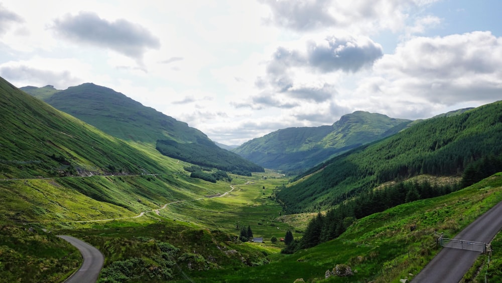 a scenic view of a valley with mountains in the background