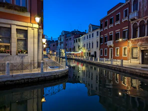 Colorful houses lining the canals of Amsterdam under a soft sunset.
