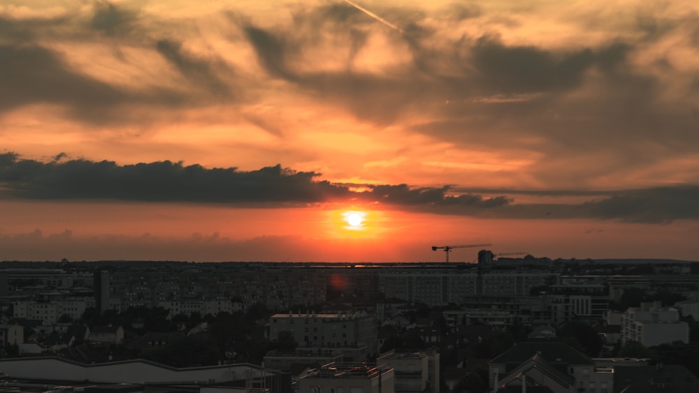 the sun is setting over a city with tall buildings