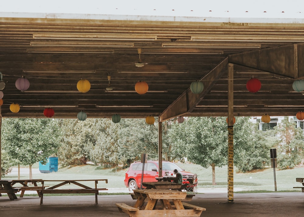 a car parked under a covered area with picnic tables