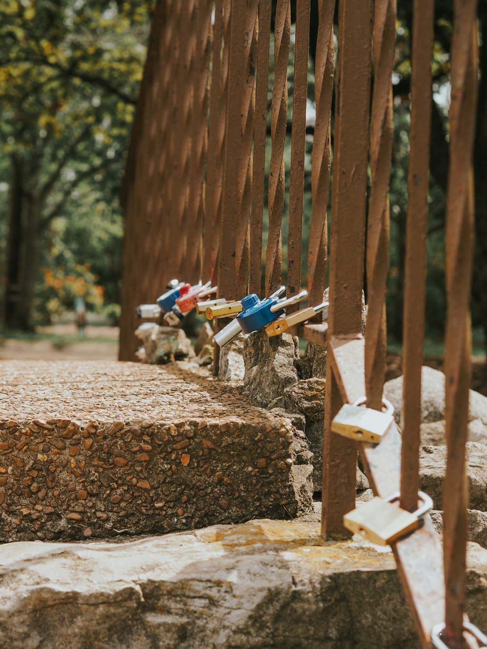 a row of wooden sculptures sitting on top of a stone wall
