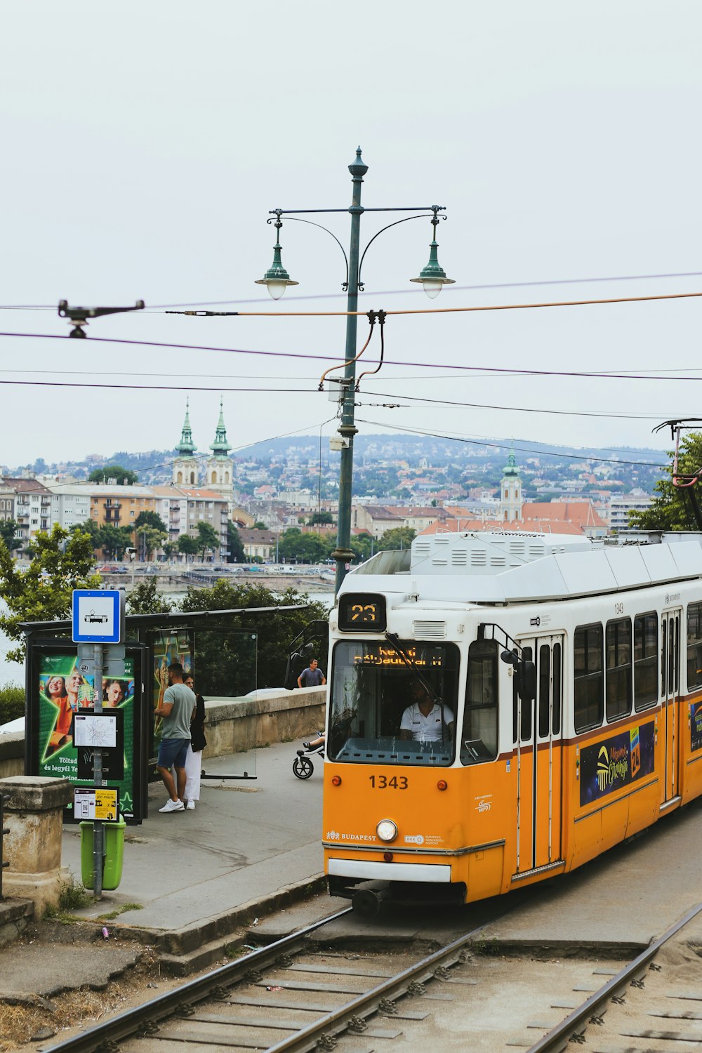 a yellow and white bus traveling down train tracks