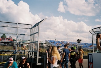 A group of people gathered at a motorsport event, engaging in discussions.