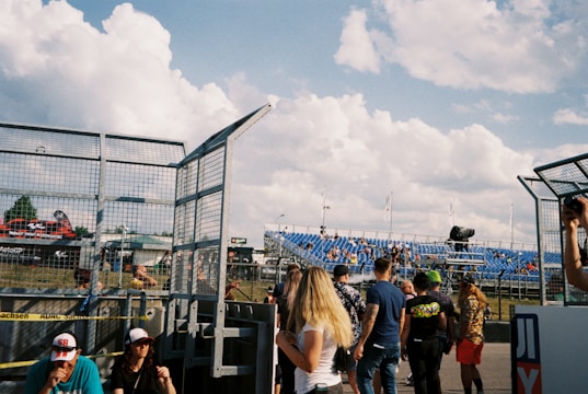 A group of people gathered at a motorsport event, engaging in discussions.