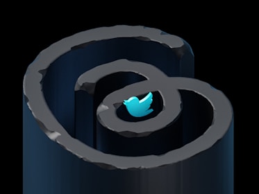 A blue Twitter bird icon is placed within a spiral-shaped structure, creating a visual that resembles a labyrinth. The image has a modern, digital art style with metallic textures and a dark background that enhances the contrast of the bright icon.