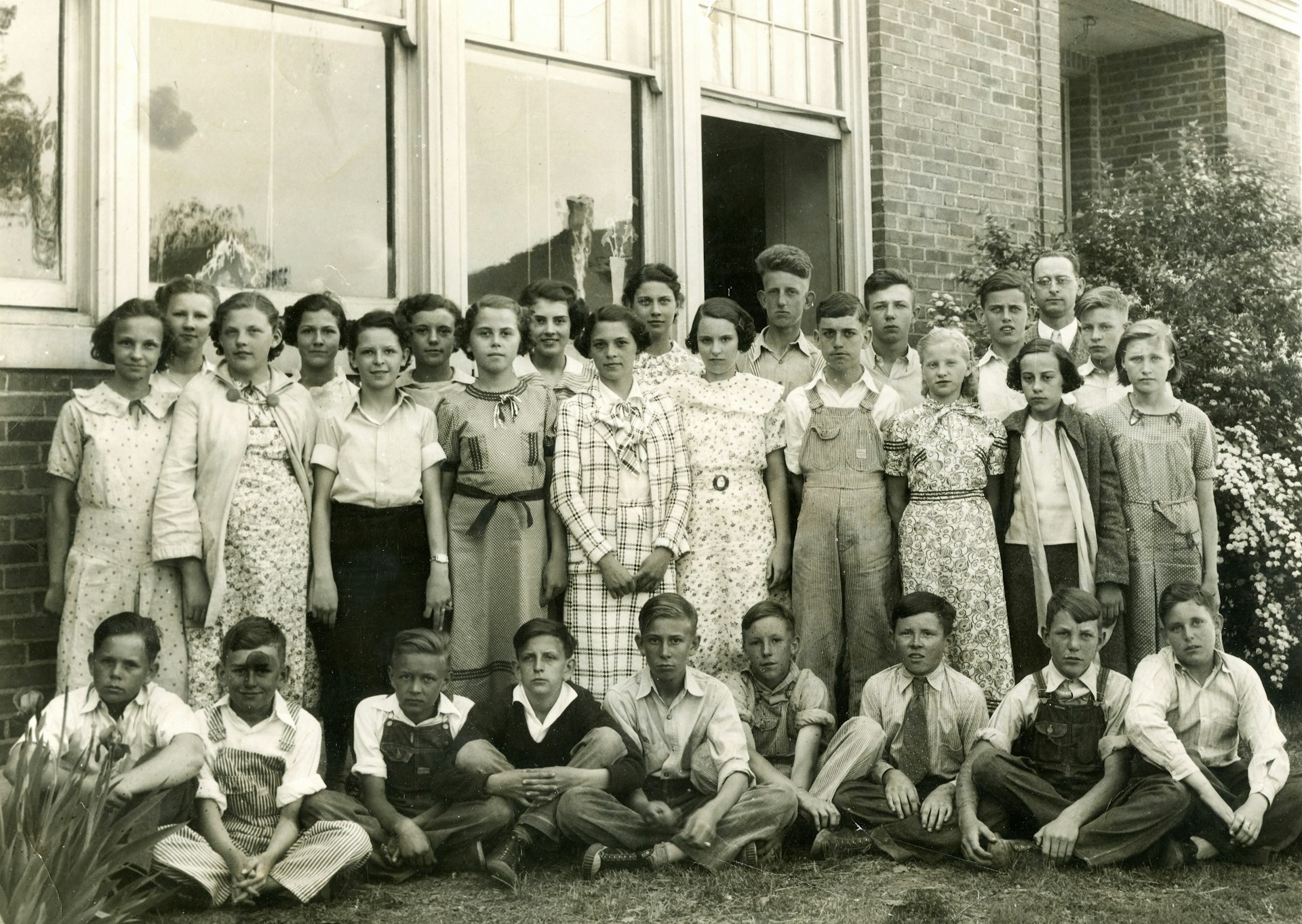A candid shot of students laughing together on campus, dressed in cherry red and cream vintage outfits with retro backpacks and heart-shaped sunglasses.