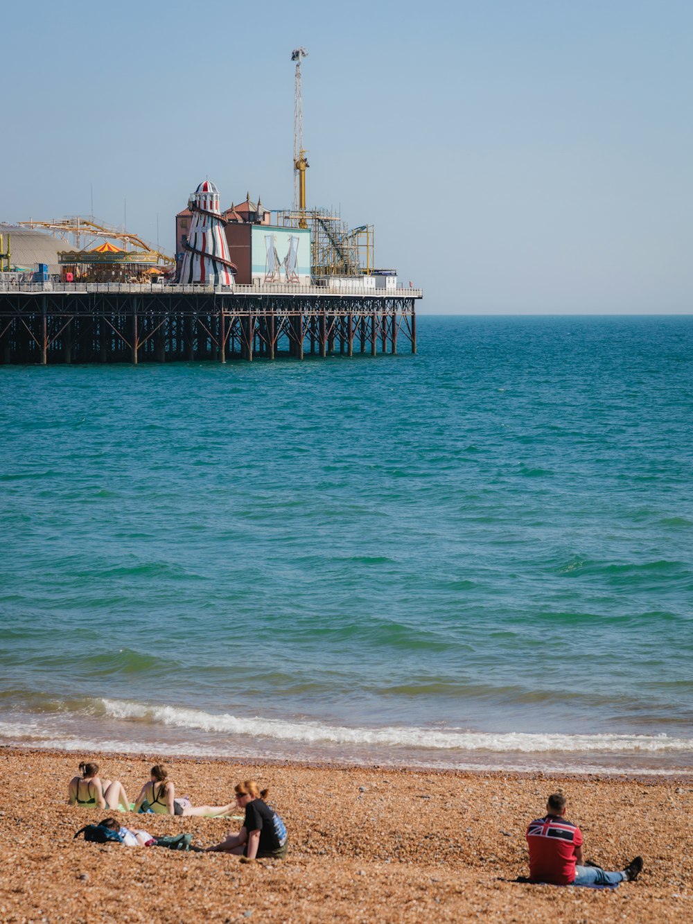 a group of people sitting on top of a sandy beach