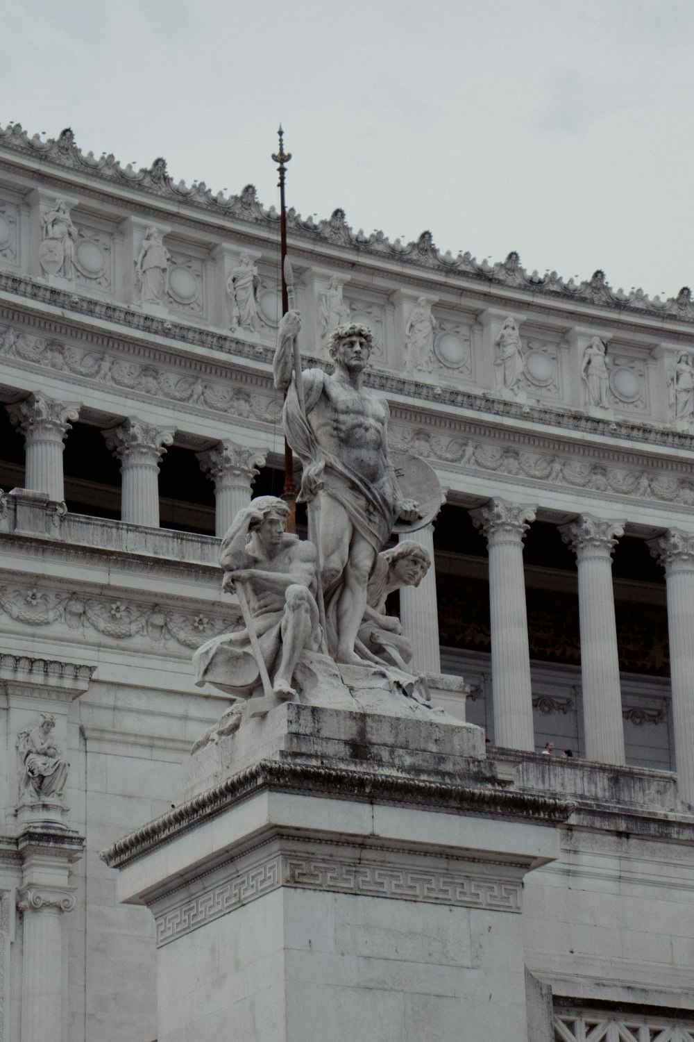 a statue of a man holding a cross in front of a building