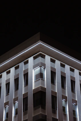 Modern townhouse with sleek black and white facade and neon blue lighting accents.