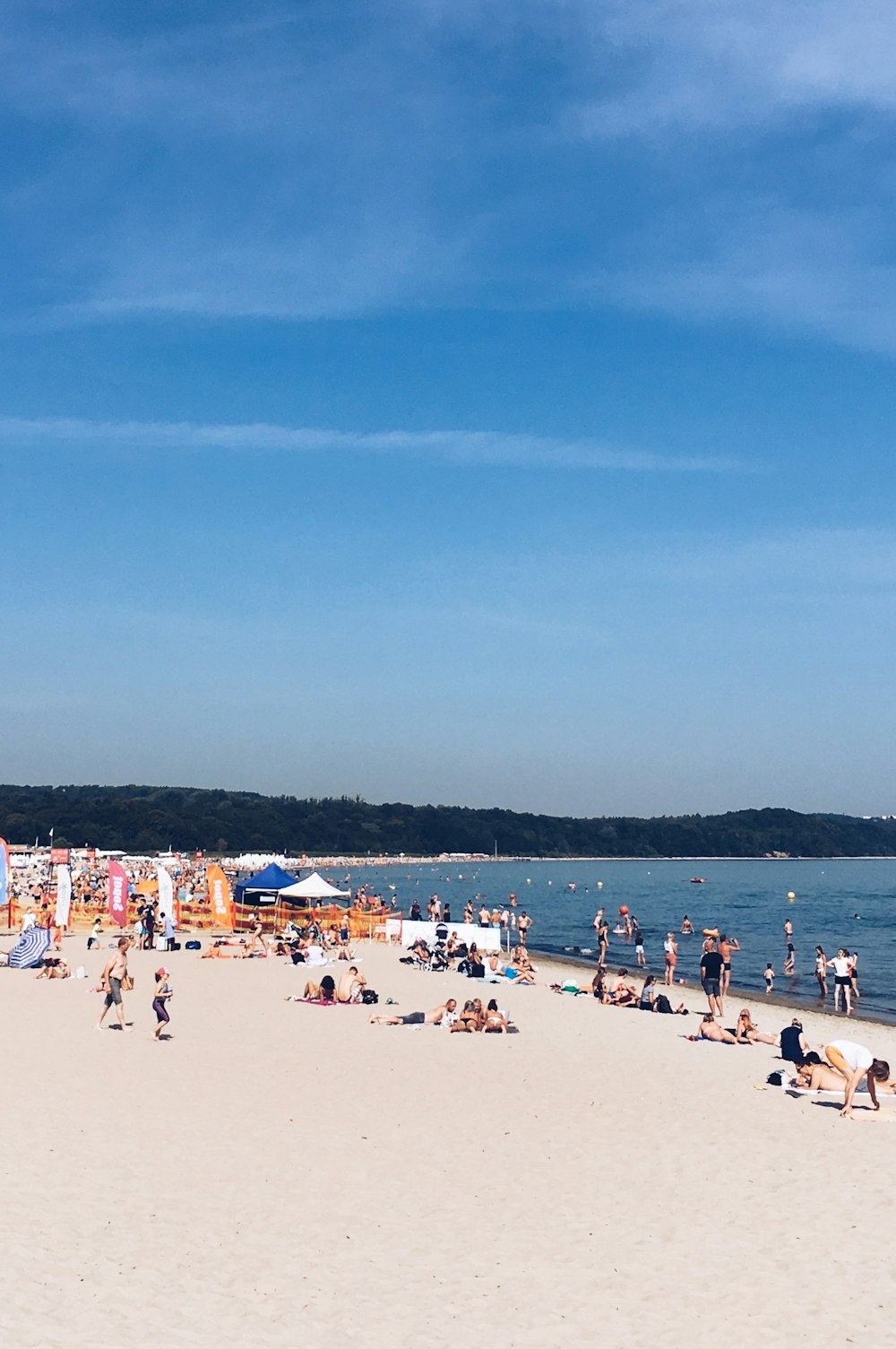 a crowded beach with people and umbrellas on a sunny day
