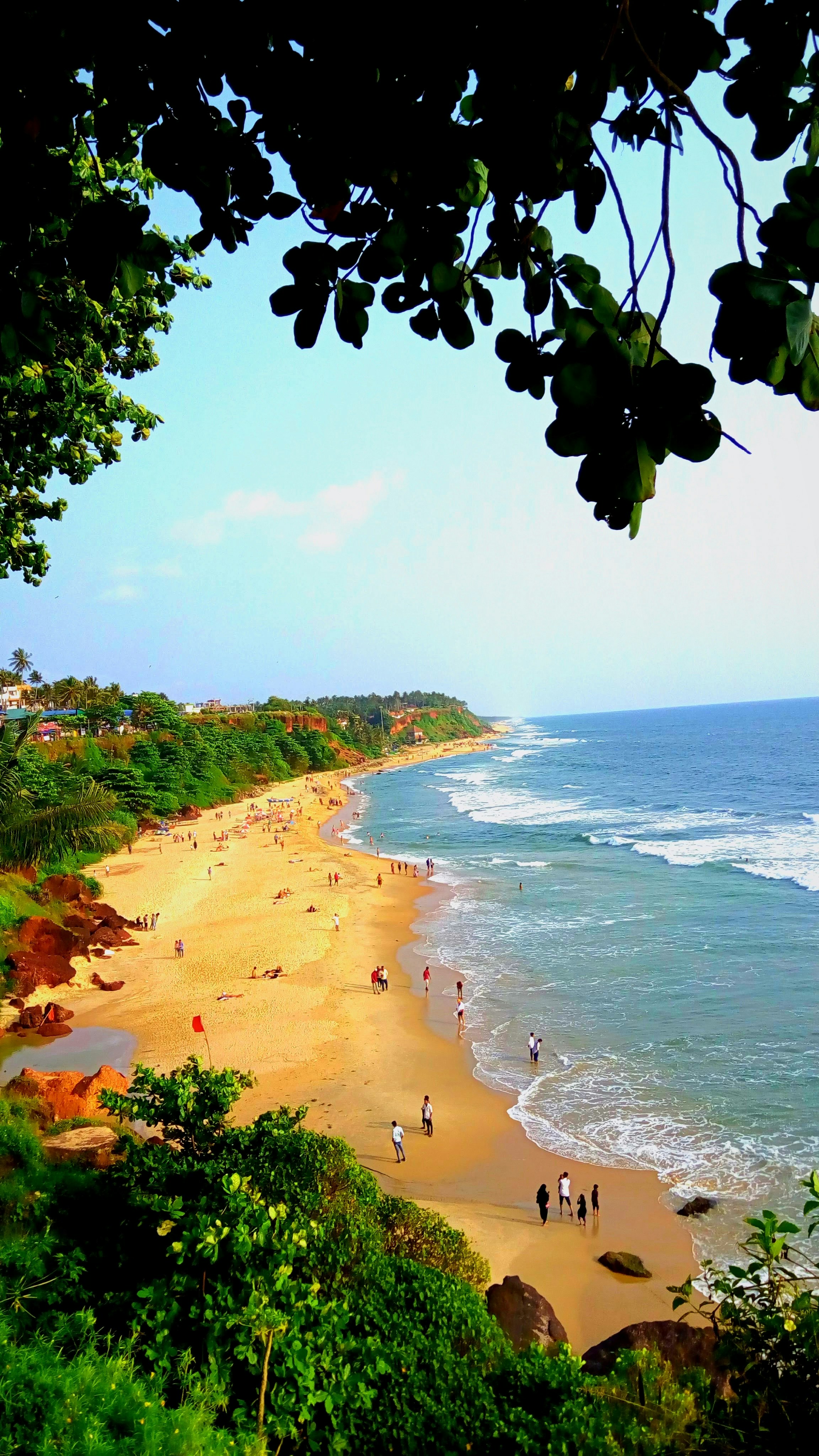 a group of people walking along a beach next to the ocean
