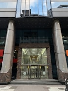 Image of a sleek glass door entrance to an office building.