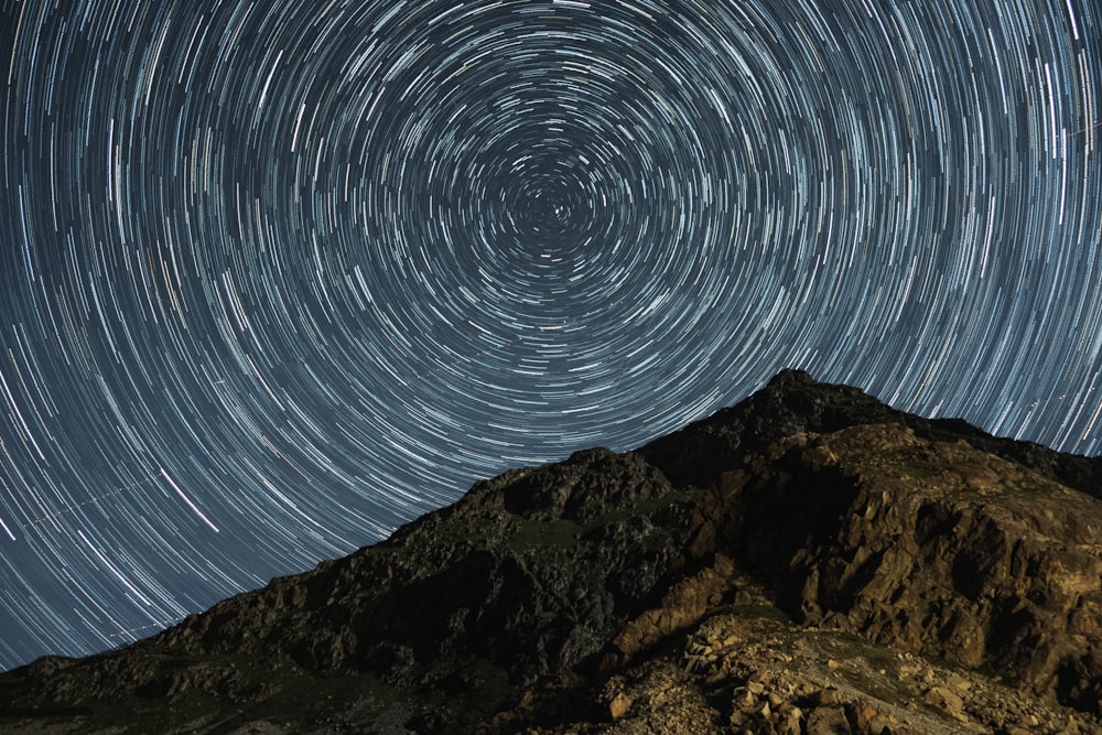 a mountain with a star trail in the sky