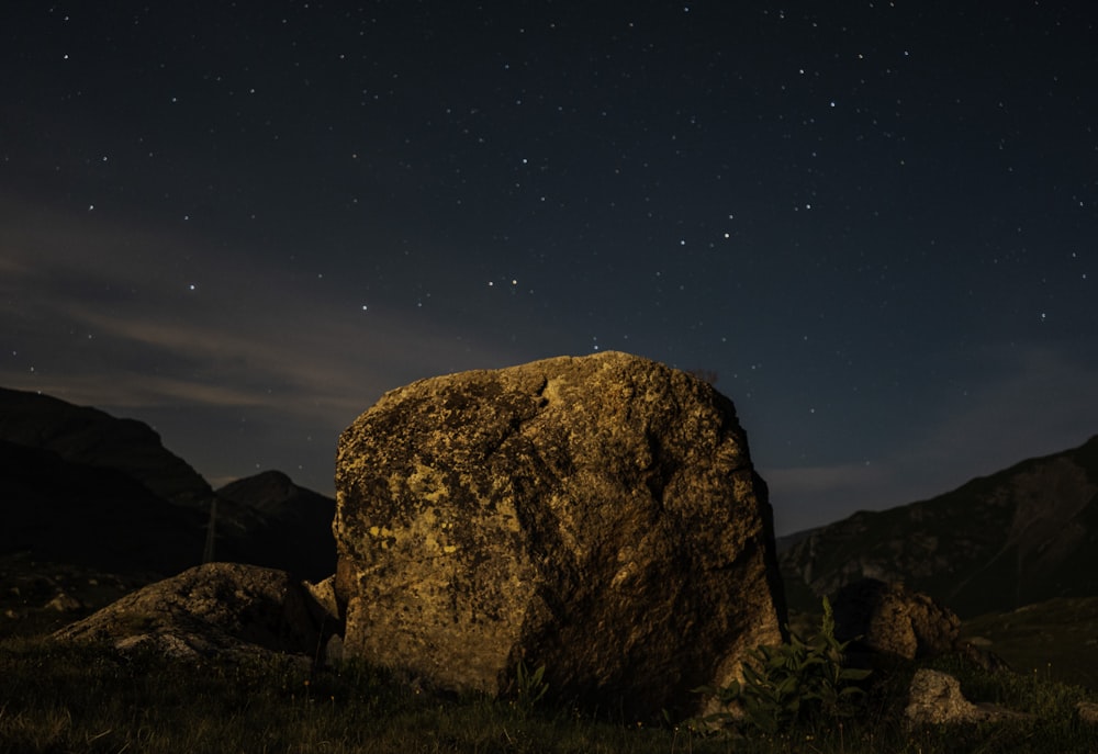 a large rock sitting in the middle of a field