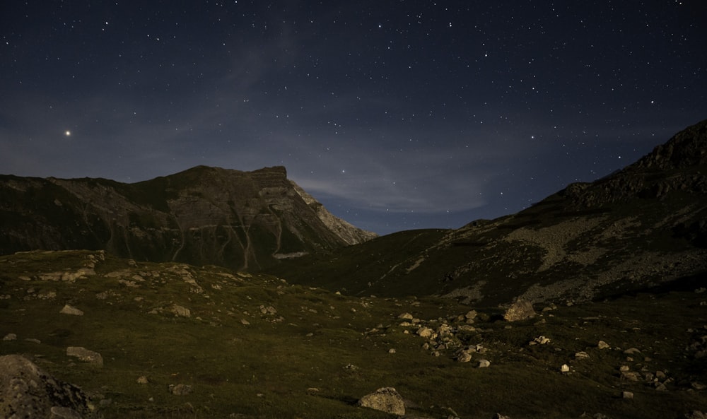 the night sky over a mountain range with stars in the sky