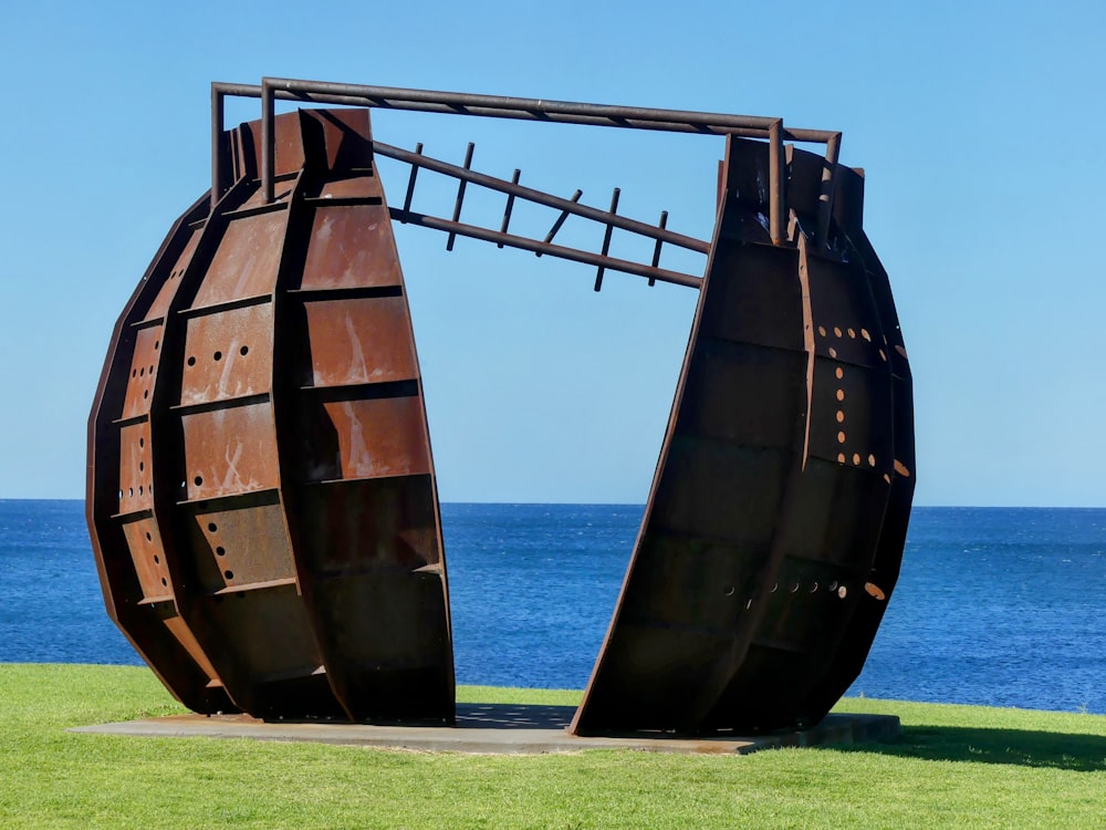 a large metal sculpture sitting on top of a lush green field