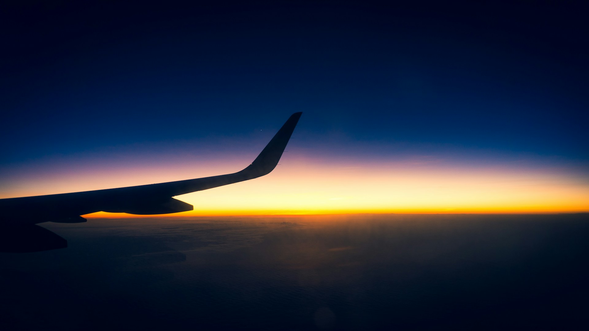 the wing of an airplane as the sun sets
