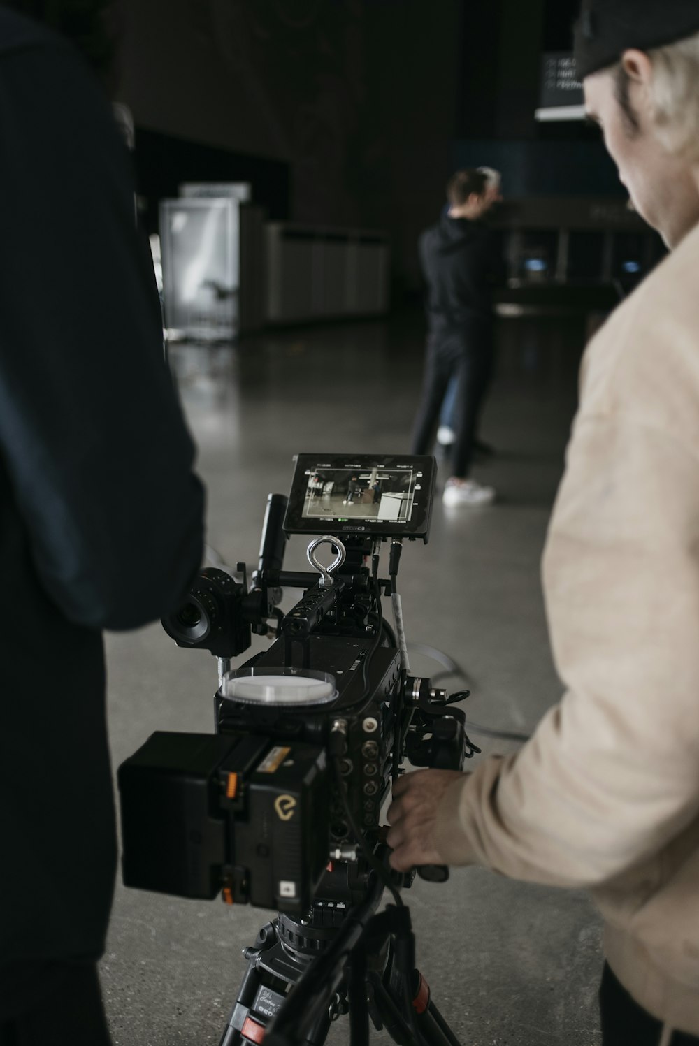 a man standing next to a camera on top of a tripod