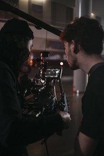 a man standing next to a camera on a tripod