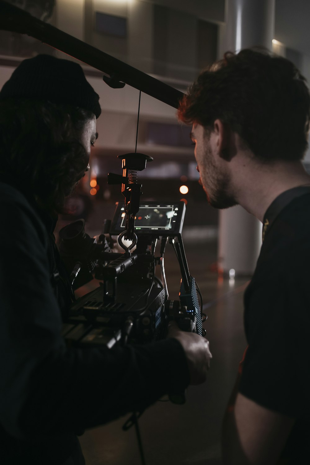 a man standing next to a camera on a tripod