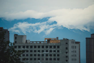A serene view of the Andes mountains behind a modern condominium complex.