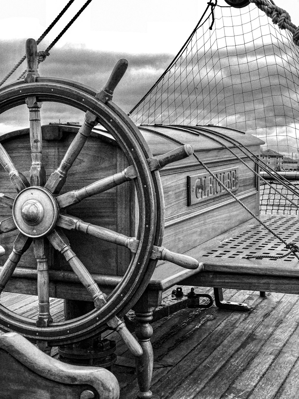 a black and white photo of a ship's steering wheel