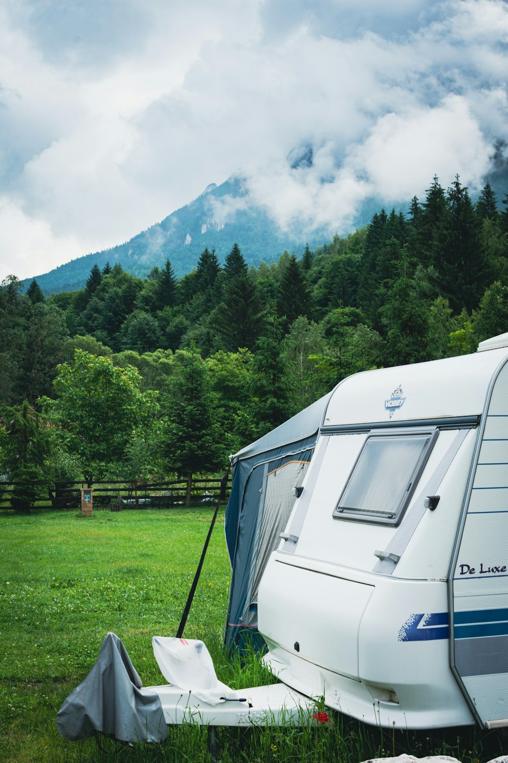 a camper parked in a field with mountains in the background